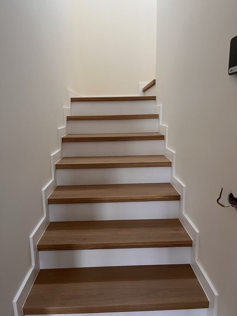 The same stairs after cladding, with oak treads and white risers